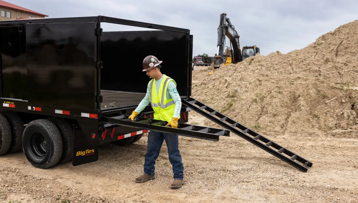 Man moving ramps on Big Tex Dump Trailer