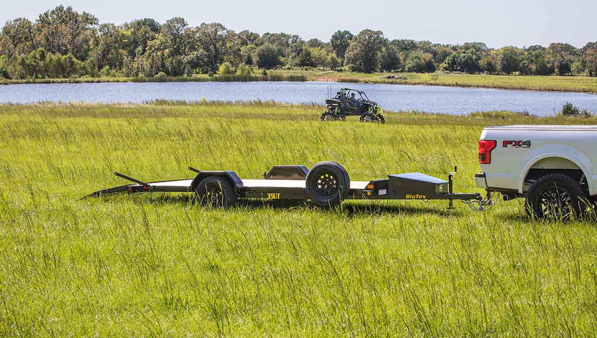 a ford f150 is towing a 35ut atv flatbed trailer