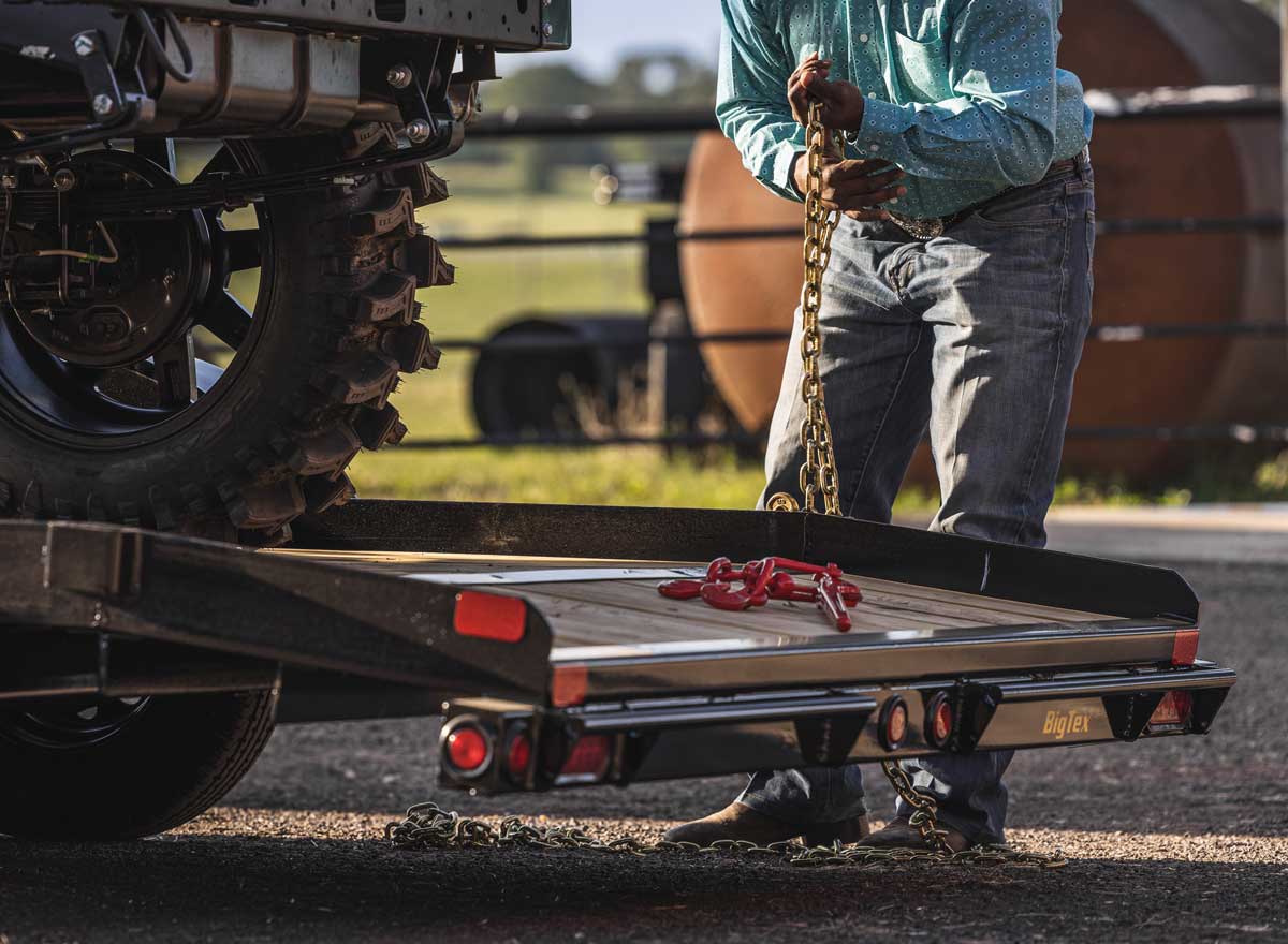 Man Holding Chain Working on Trailer