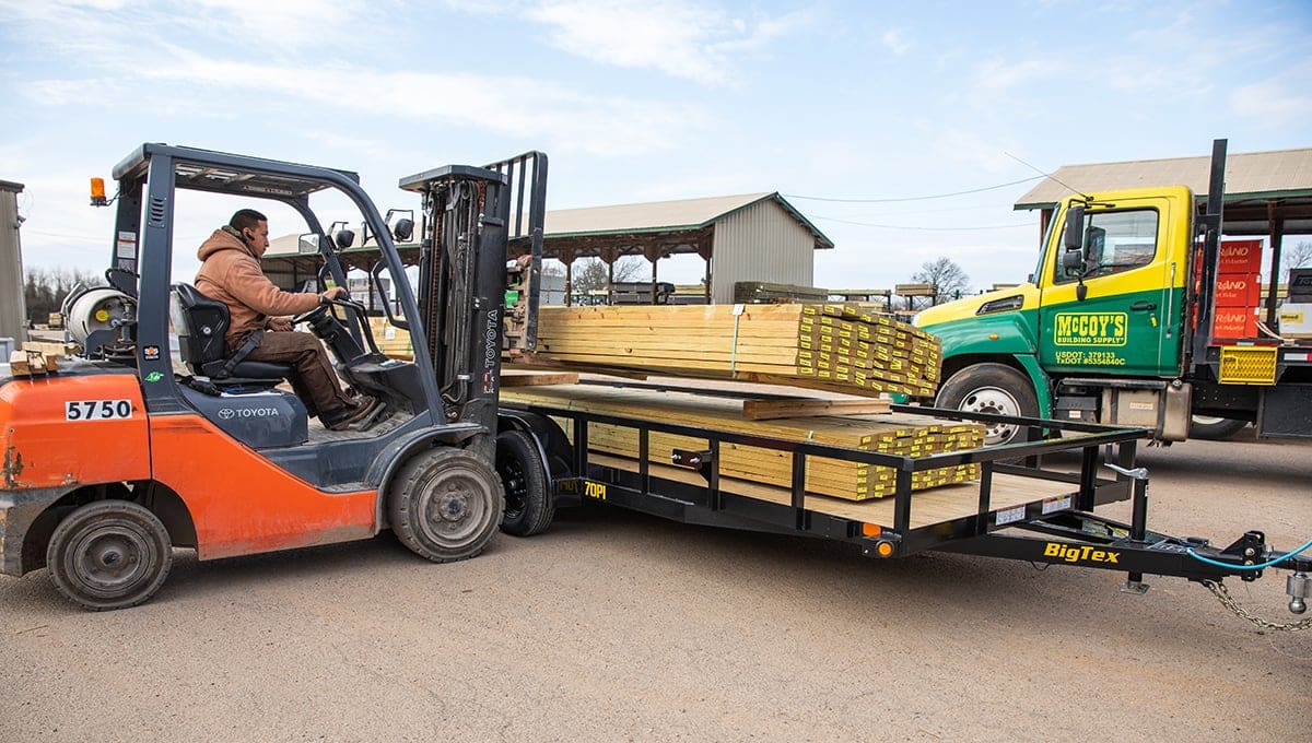 a man driving a forklift with the number 57.50 on it