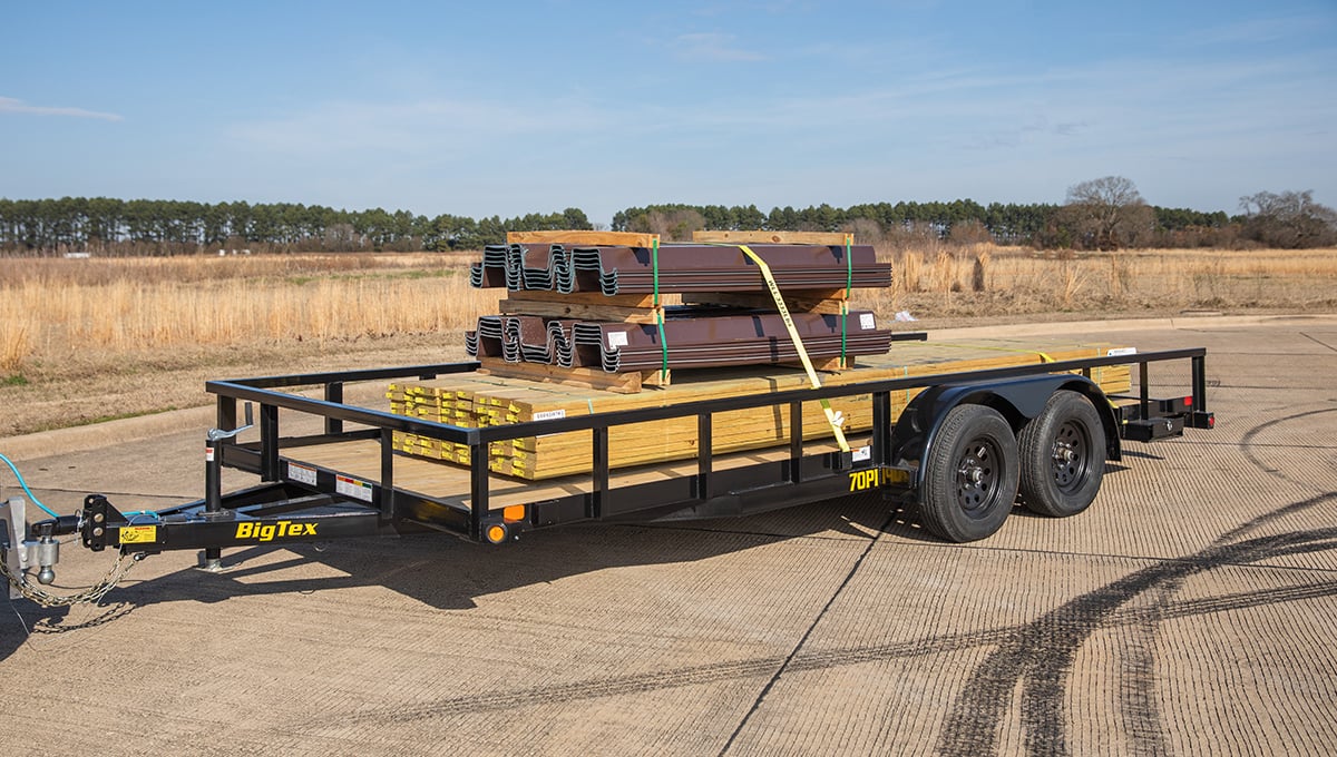 a 70pi utility big tex trailer with a stack of wood on it