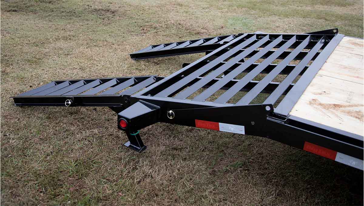 a 10ET equipment hauler trailer with a wooden deck is sitting in the grass