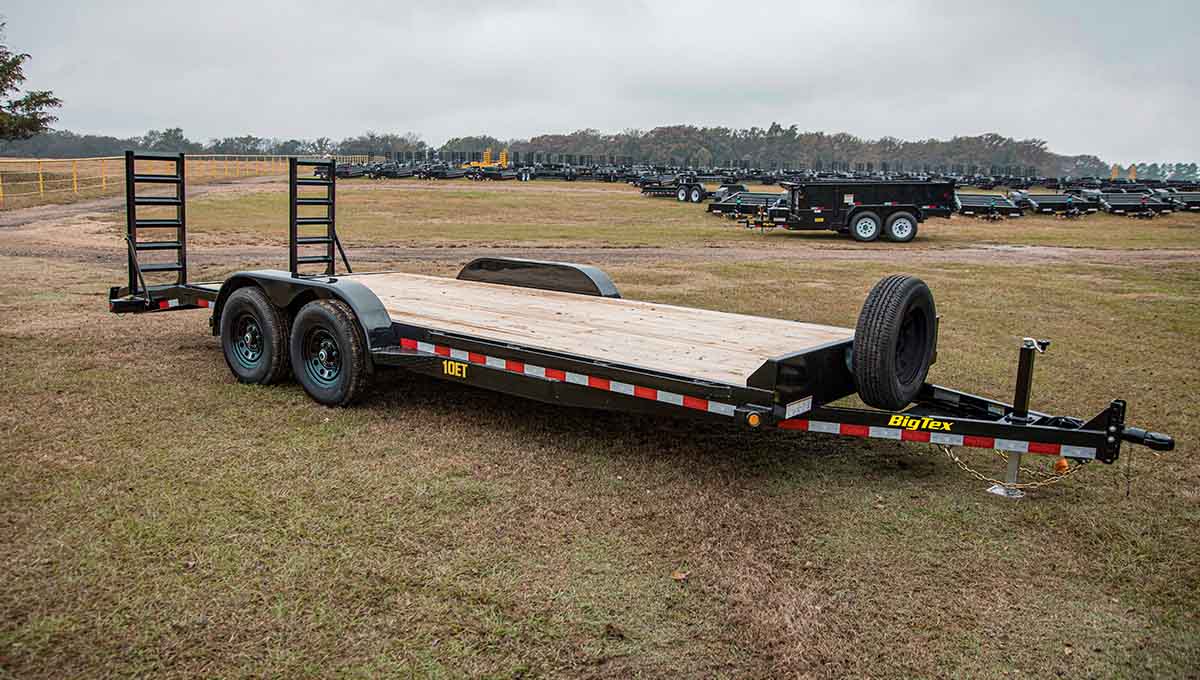 a 10et equipment big tex trailer is parked in a grassy field