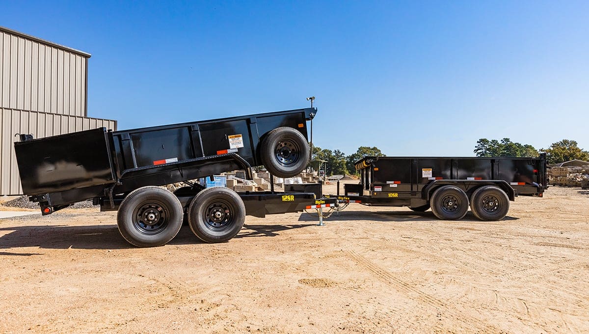 a dump truck with a 12sr light commercial dump trailer attached to it has a warning sign on the side