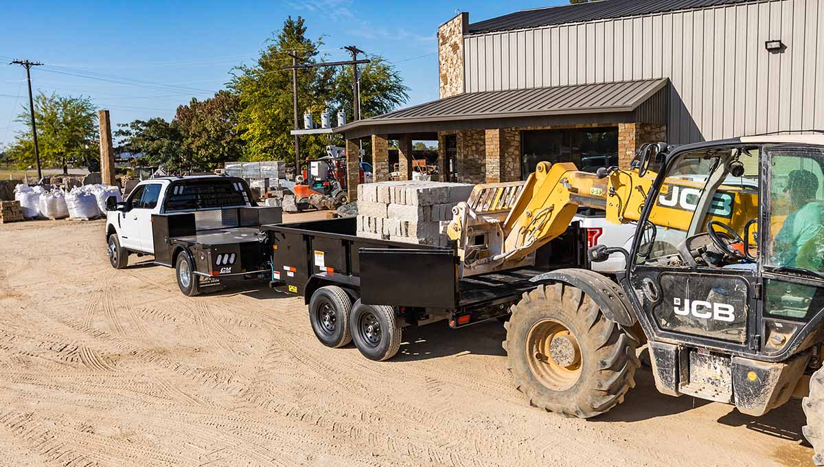 a jcb truck is pulling a 12sr commercial dump trailer with bricks on it