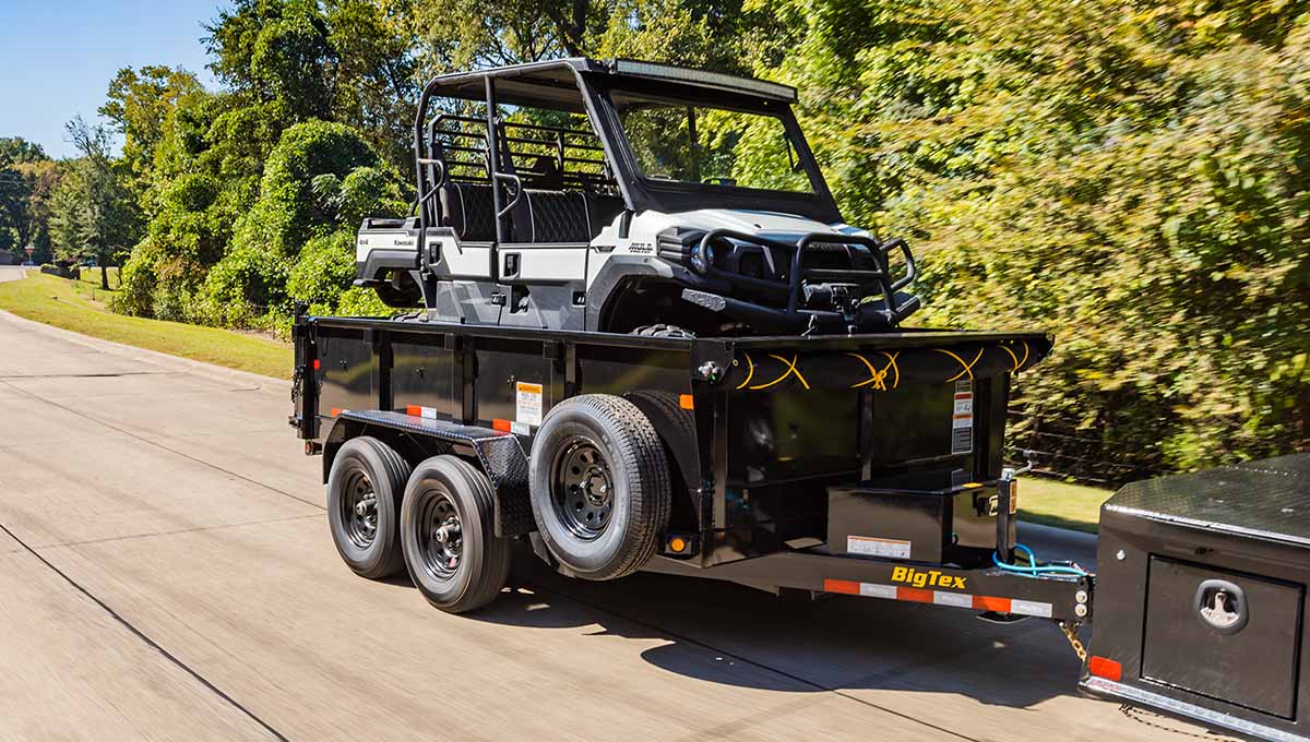 a big tex 12sr dump trailer is pulling a utility vehicle