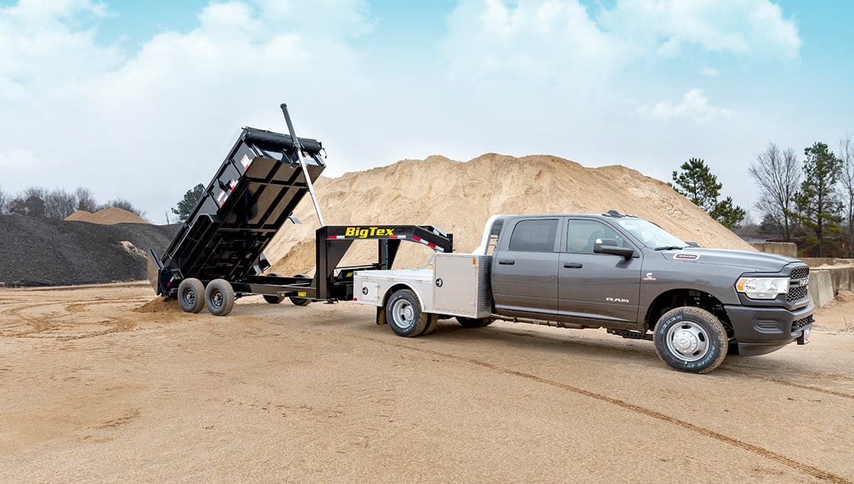 a ram truck with a big tex 14gt dump trailer attached to it