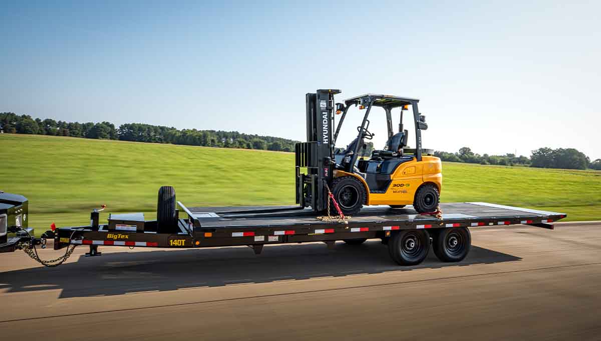 a forklift is on a 140t flatbed tilt trailer