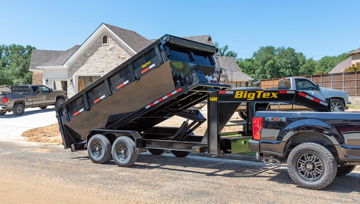 a black truck is pulling a 14rd big tex dump trailer