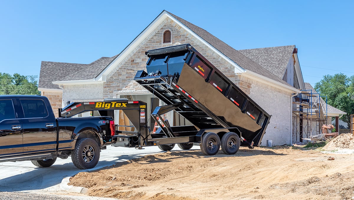 a black truck is pulling a 14rd big tex dump trailer