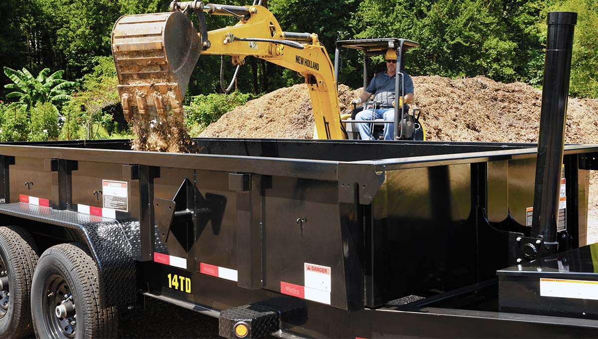 a man is driving an excavator on a 14td dump trailer