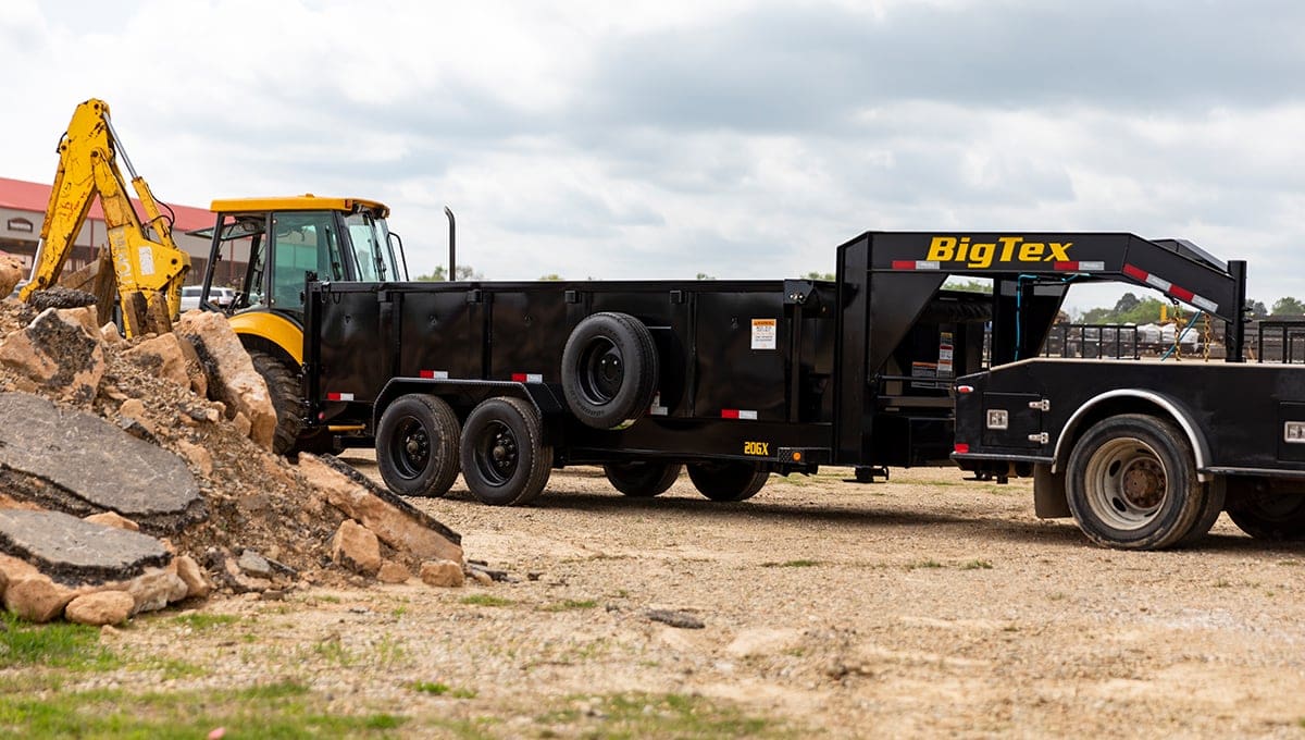 a 20gx dump big tex trailer is being pulled by a tractor