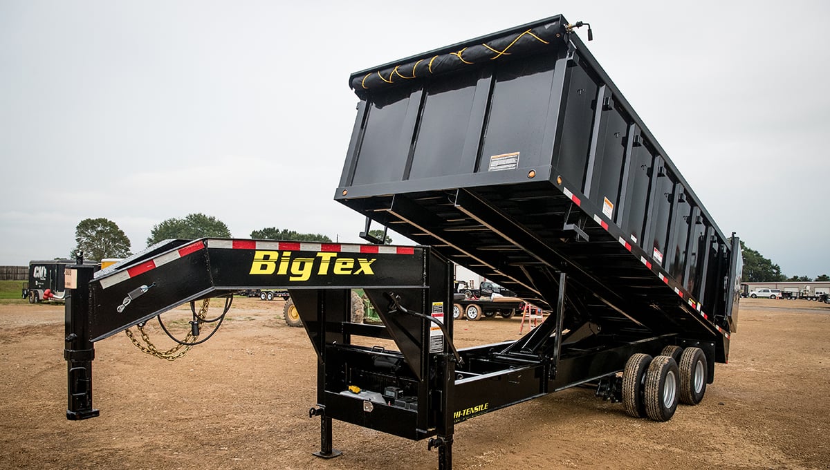 a 25du big tex dump trailer is parked in a dirt field