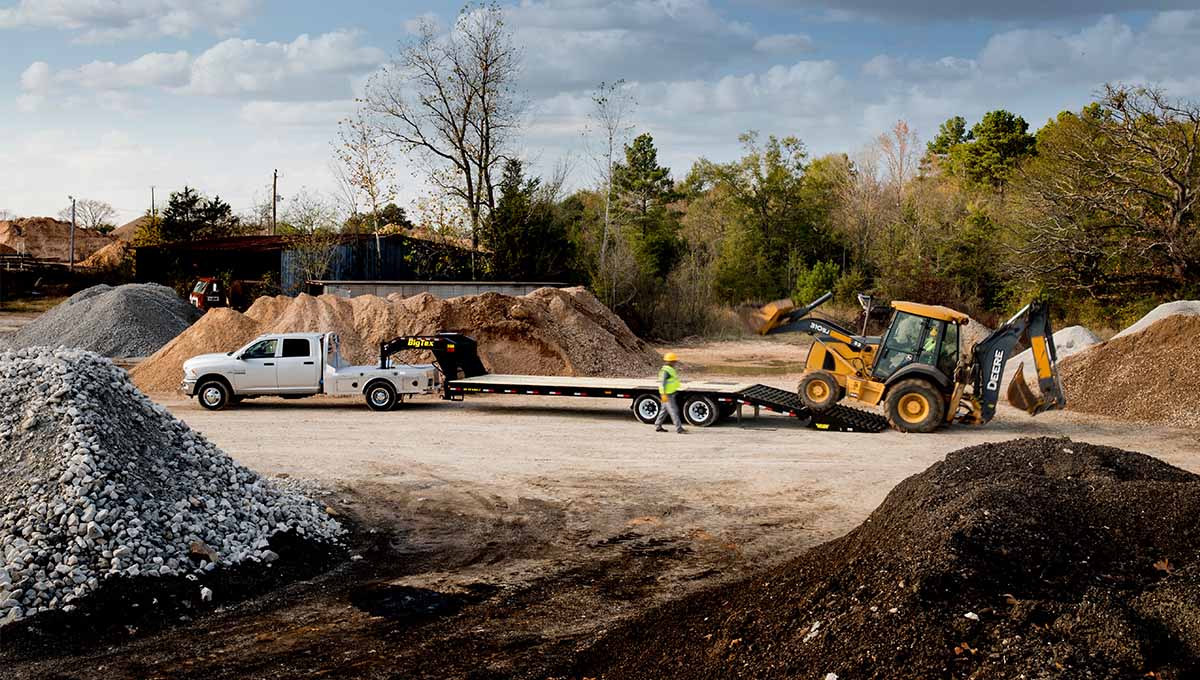 a white truck is being towed by a 3xgn flatbed gooseneck trailer