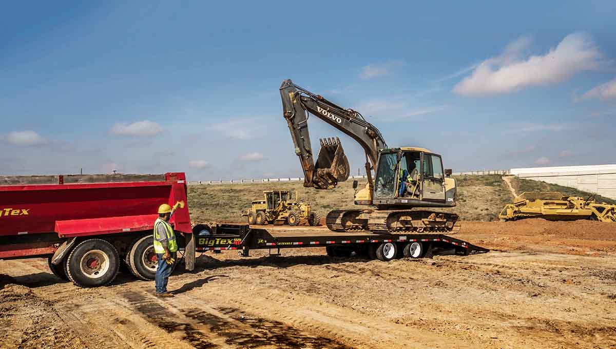 a volvo excavator is being loaded onto a trailer