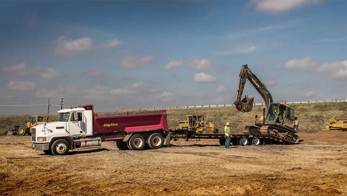 a volvo excavator is loading dirt into a dump truck