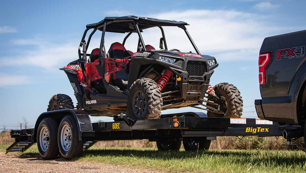 a polaris atv is being towed by a 60ec car hauler big tex trailer