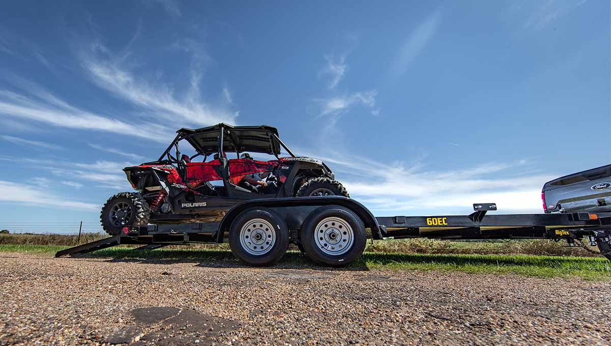 a polaris atv is on a trailer with a ford truck behind it