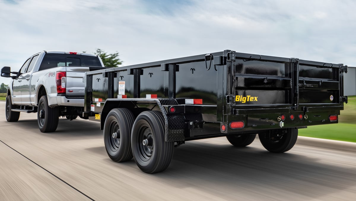 a truck is hauling a 90sr compact big tex dump trailer