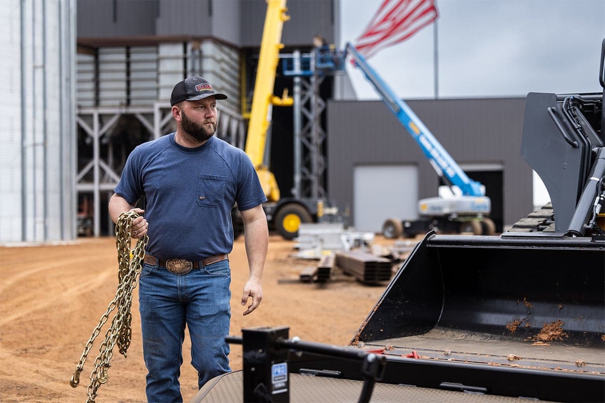 Man Holding Link Chain and Working With Equipment